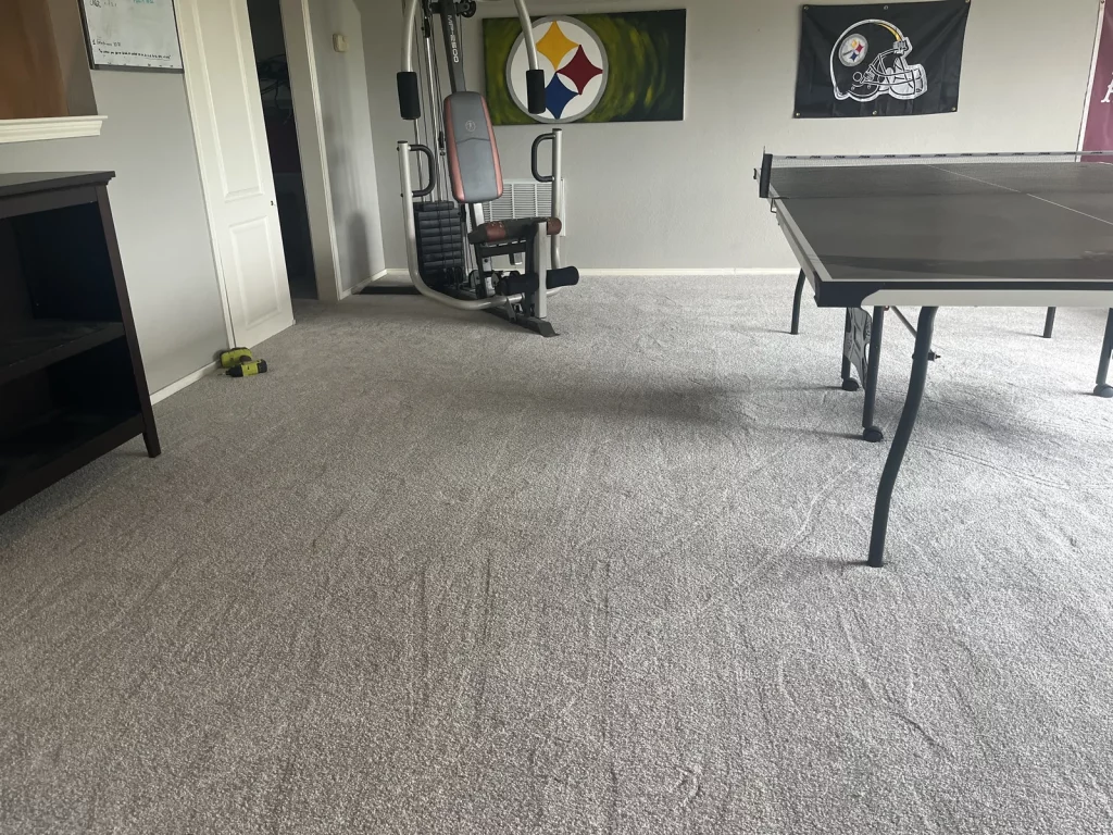 The same bonus room with new grey carpet laid wall to wall