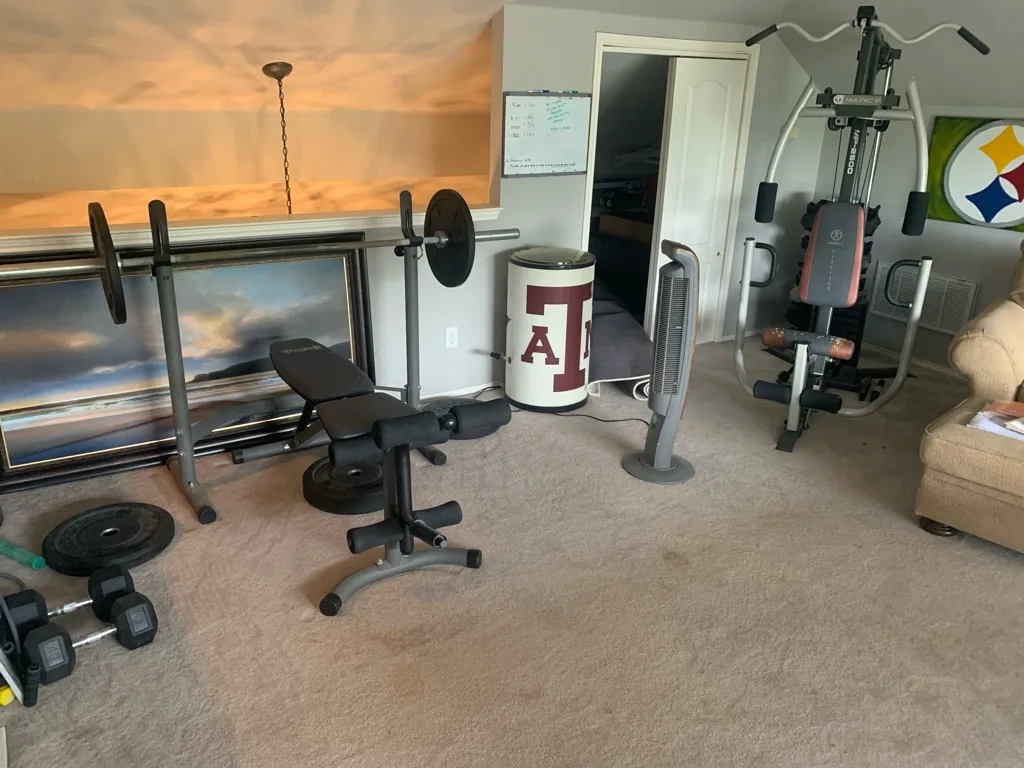 Bonus room with worn tan carpet flattened through the middle of the floor