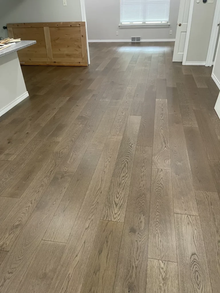 The same living room with a matte light wide-plank white oak floor