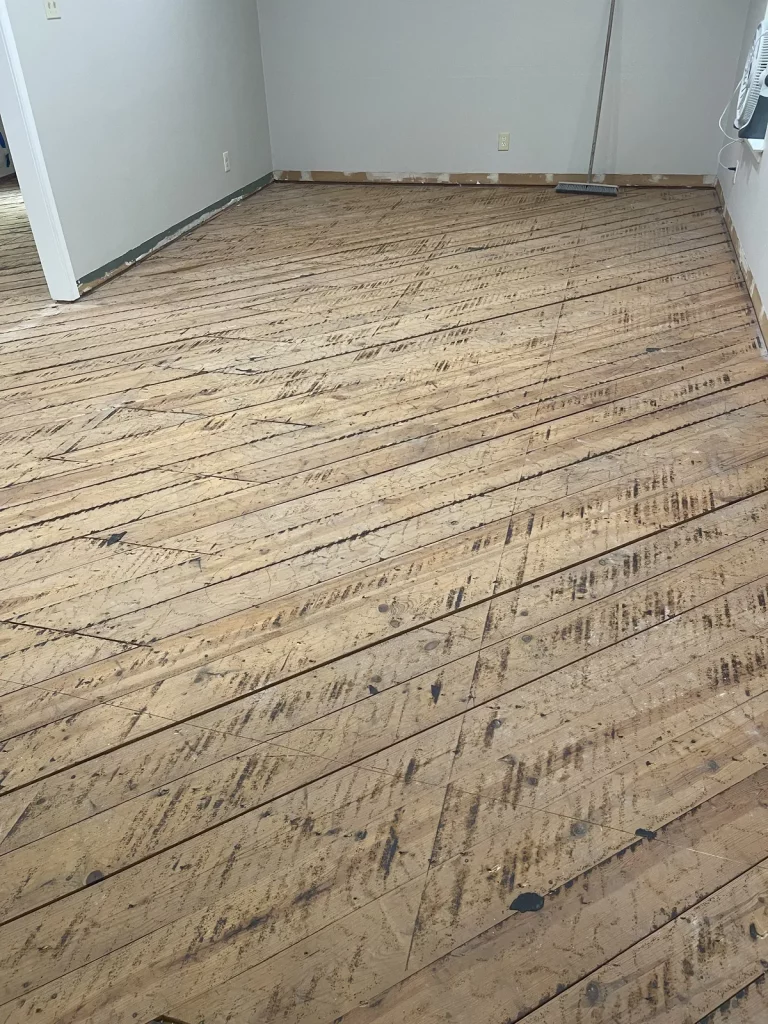 The old hardwood lifted out, exposing the plank subfloor underneath